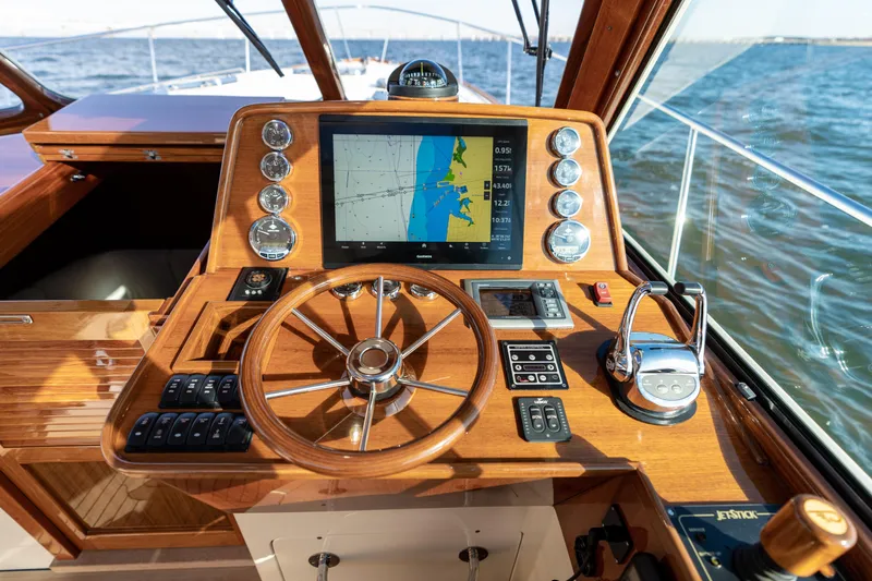Upshort Yacht Photos Pics Helm of 2010 Hinckley Talaria 44 MKII Express with navigation display and wooden steering wheel.