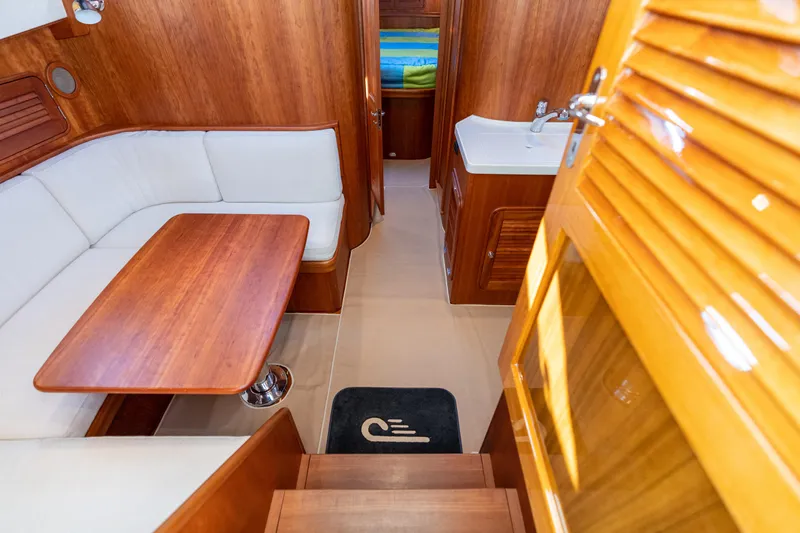 Upshort Yacht Photos Pics Interior of 2010 Hinckley Talaria 44 MKII Express with wood finish and white seating.
