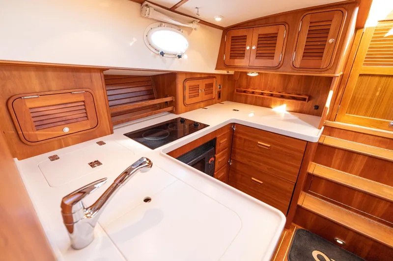 Upshort Yacht Photos Pics Luxurious 2010 Hinckley Talaria 44 MKII Express yacht kitchen with wood cabinetry and modern amenities.