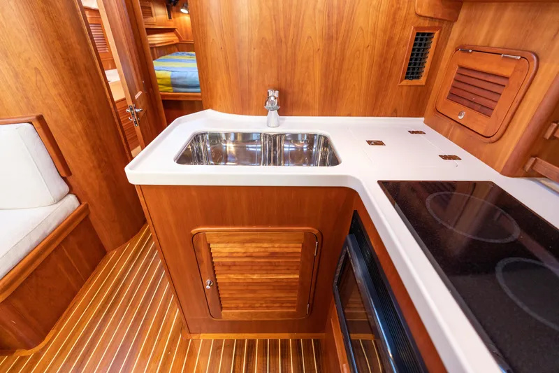 Upshort Yacht Photos Pics Luxurious 2010 Hinckley Talaria 44 MKII Express yacht interior with wooden cabinetry and modern kitchen amenities.
