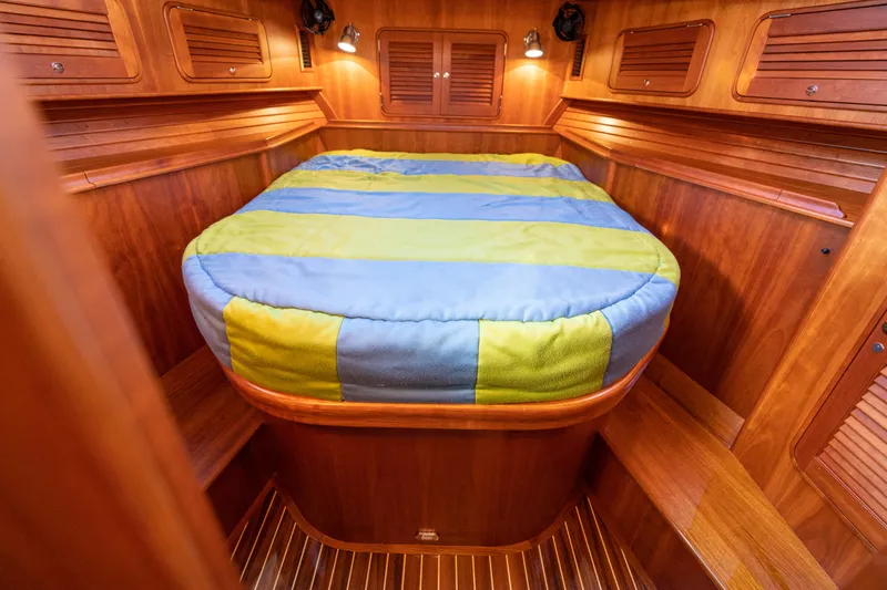 Upshort Yacht Photos Pics 2010 Hinckley Talaria 44 MKII Express cabin with wooden interior and colorful bedding.