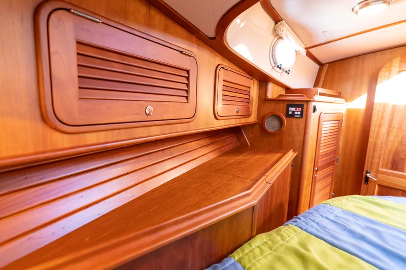 Upshort Yacht Photos Pics Interior of 2010 Hinckley Talaria 44 MKII Express, featuring wooden cabinetry and cozy sleeping area.