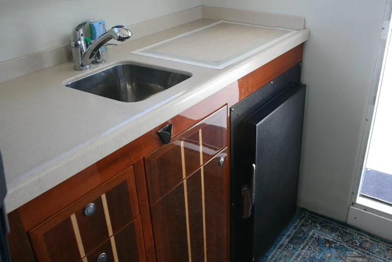 Gypsy Spirit Yacht Photos Pics Compact kitchen area in a 2011 Ocean Sport Roamer 30' boat, featuring a sink and cabinetry.