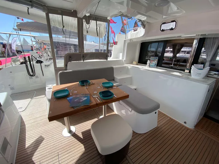  Yacht Photos Pics 2025 Lagoon 46 yacht interior with dining area, modern seating, and elegant tableware.