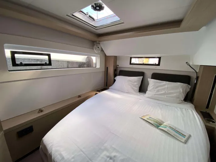  Yacht Photos Pics Luxurious cabin interior of 2025 Lagoon 46 yacht with skylight and cozy bedding.