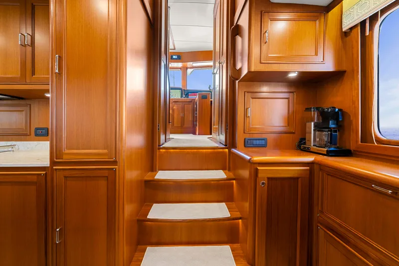 Yacht Photos Pics Luxurious wooden interior of 2023 Fleming 65 yacht with stairs and cabinetry.