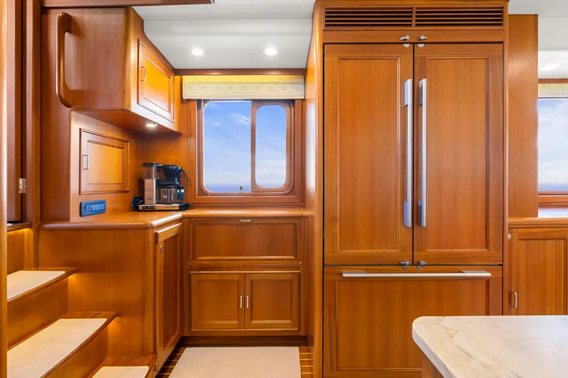  Yacht Photos Pics Luxurious 2023 Fleming 65 yacht kitchen with wooden cabinetry and modern appliances.