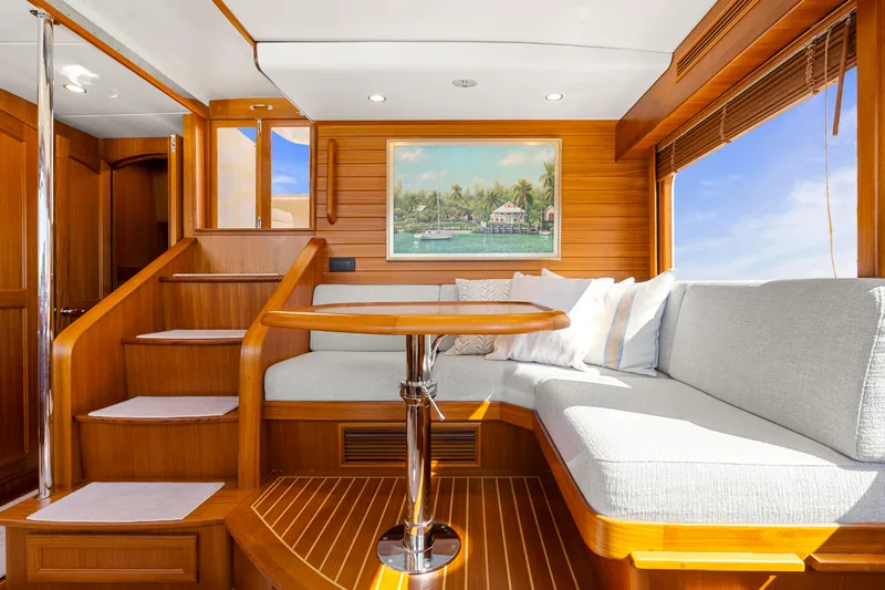  Yacht Photos Pics Luxurious interior of 2023 Fleming 65 yacht with elegant wood finish and cozy seating area.