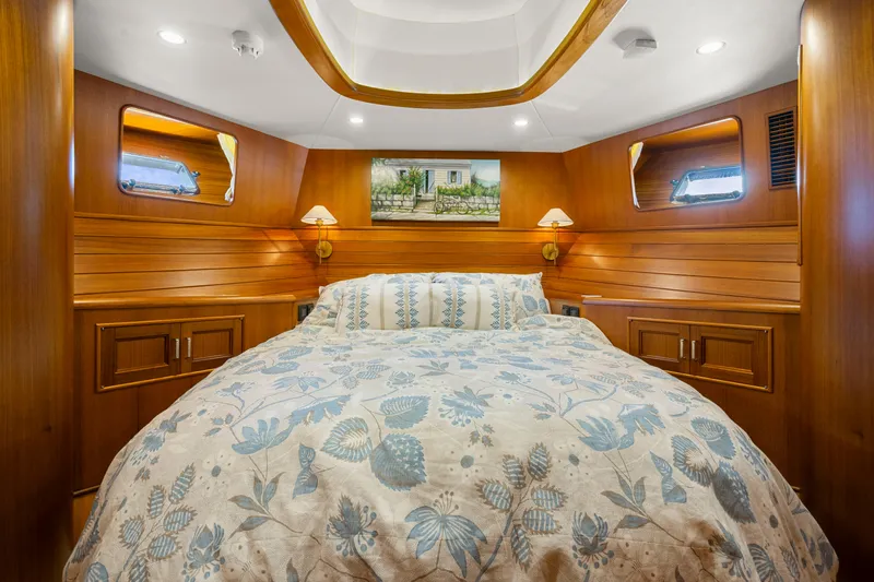  Yacht Photos Pics Luxurious cabin interior of 2023 Fleming 65 yacht with elegant wood paneling and cozy bedding.