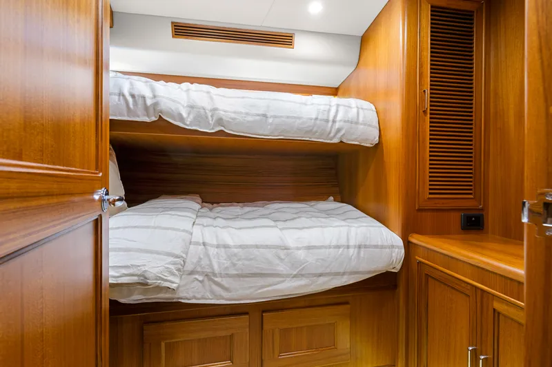  Yacht Photos Pics 2023 Fleming 65 yacht cabin with wooden interior and bunk beds.