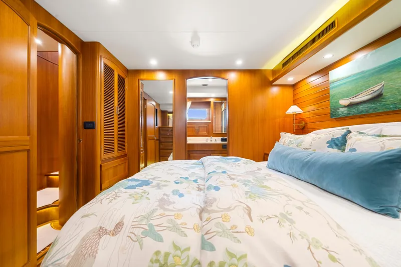 Yacht Photos Pics Luxurious bedroom in 2023 Fleming 65 yacht with wooden interiors and elegant bedding.
