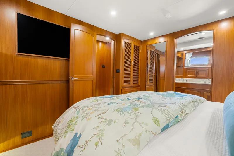  Yacht Photos Pics Luxurious bedroom interior of 2023 Fleming 65 yacht with wood paneling and modern amenities.