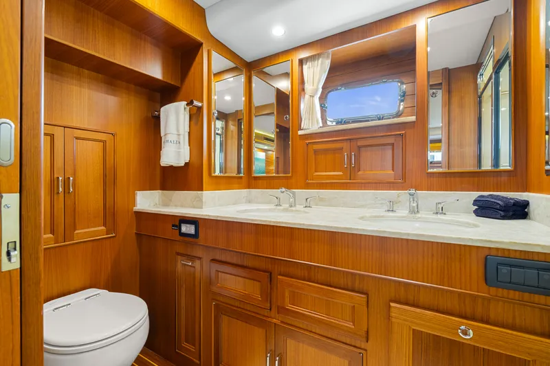  Yacht Photos Pics Luxurious bathroom in 2023 Fleming 65 yacht with wooden cabinetry and dual sinks.