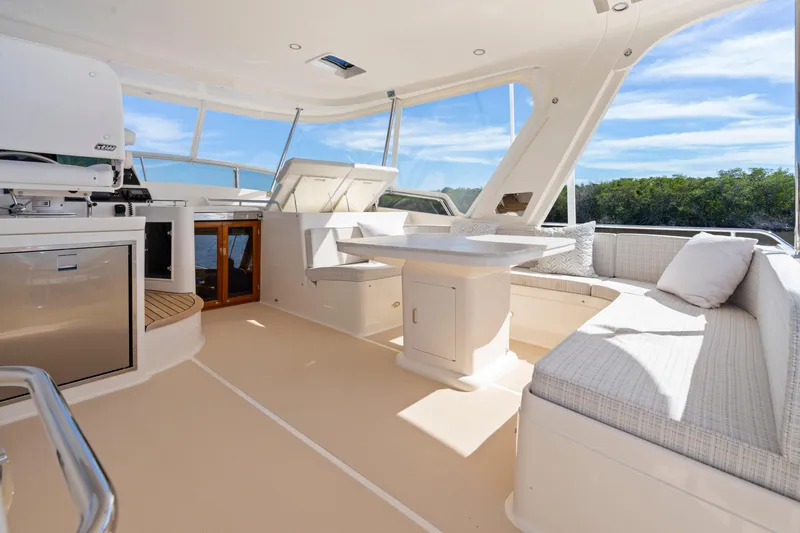 Yacht Photos Pics Luxurious 2023 Fleming 65 yacht interior with seating, table, and panoramic windows.