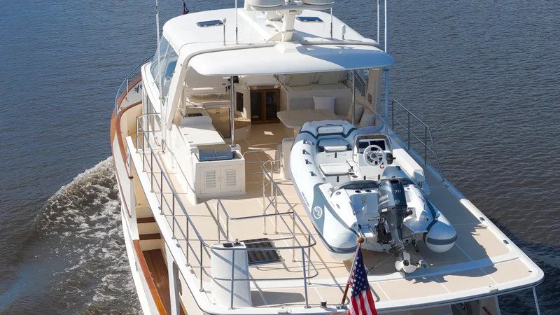  Yacht Photos Pics Luxury Fleming 65 yacht cruising on water, 2023 model, with tender boat on deck.