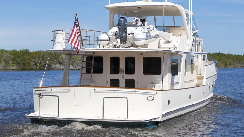  Yacht Photos Pics Luxury Fleming 65 yacht cruising on water, 2023 model, with American flag displayed.