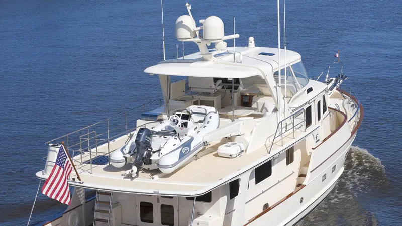  Yacht Photos Pics Luxury Fleming 65 yacht cruising on water, 2023 model, with American flag displayed.