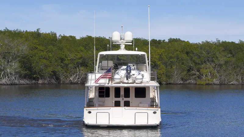  Yacht Photos Pics Fleming 65 yacht, 2023 model, cruising on calm water with lush greenery in the background.