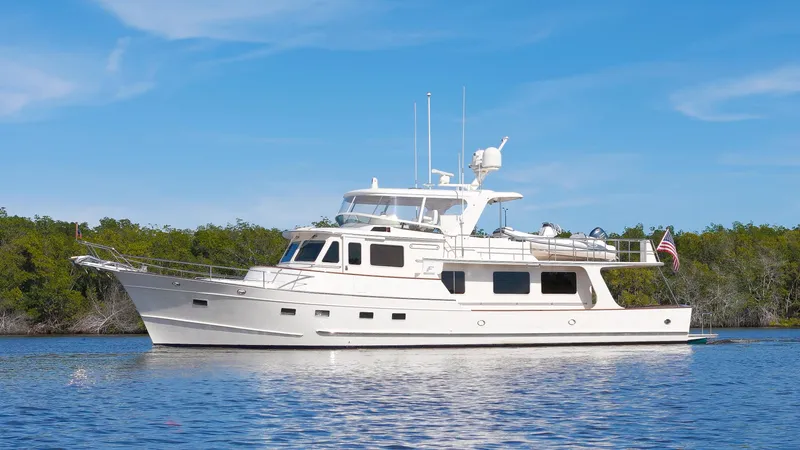  Yacht Photos Pics Luxury Fleming 65 yacht cruising on calm waters, 2023 model, under clear blue skies.