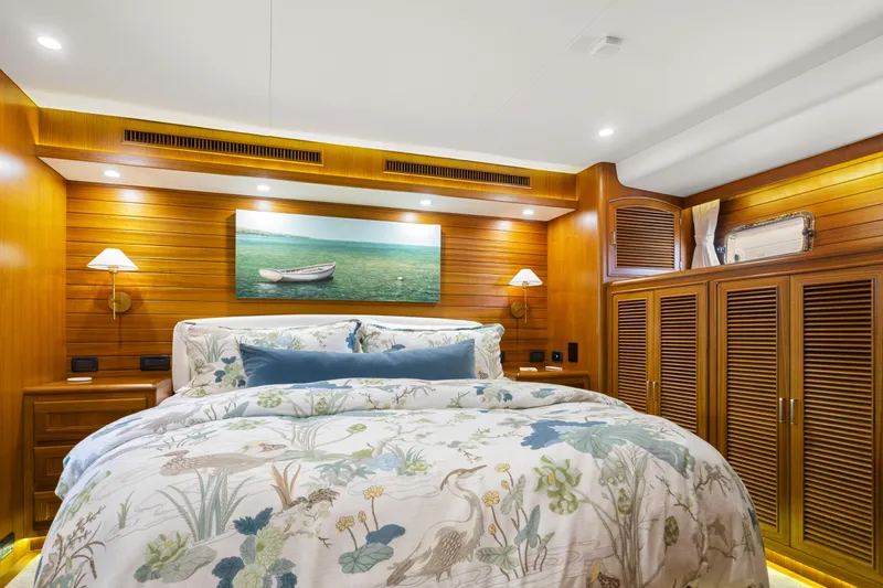  Yacht Photos Pics Luxurious bedroom interior on 2023 Fleming 65 yacht with wooden accents and elegant bedding.