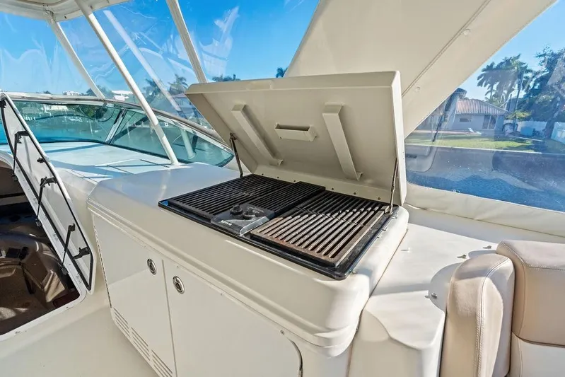 Time Out Yacht Photos Pics Outdoor grill on 2009 Carver 56 Voyager SE yacht deck, under clear blue sky.