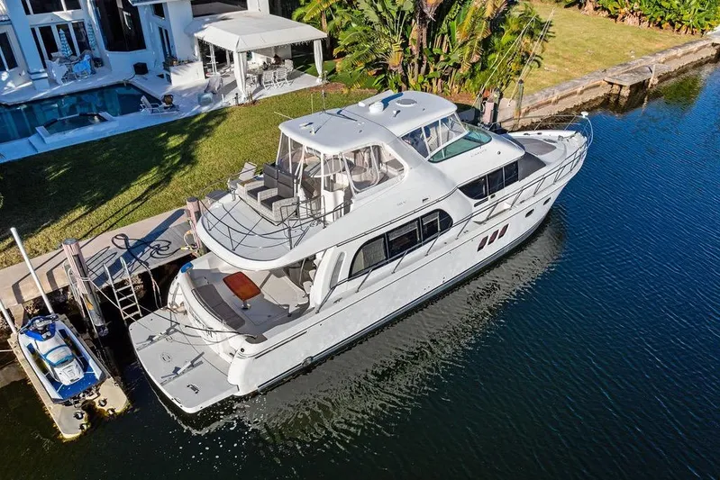 Time Out Yacht Photos Pics 2009 Carver 56 Voyager SE yacht docked by a luxurious waterfront home.