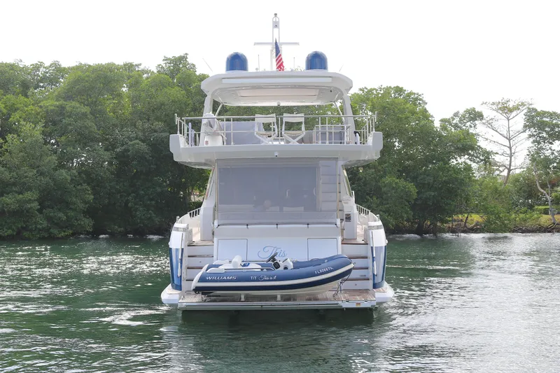 This Is It Yacht Photos Pics 2019 Azimut 72 Flybridge yacht with tender, docked near lush greenery.