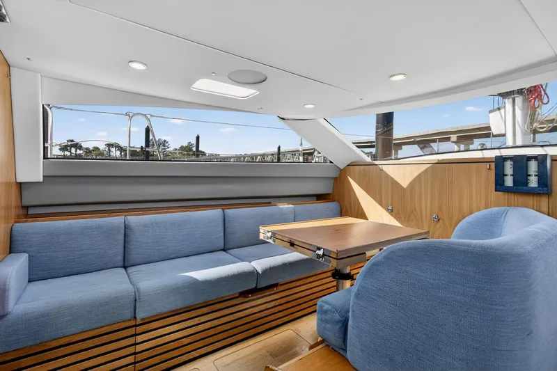 Off The Grid Yacht Photos Pics Luxurious interior of 2024 Southerly 420 yacht with blue seating and wooden accents.