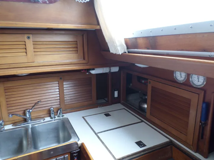 Wanderer Yacht Photos Pics 1982 Hinckley Sou'wester 59 yacht kitchen with wooden cabinets and stainless steel sink.