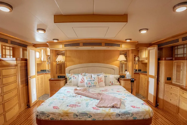 Someday Came Yacht Photos Pics Luxurious bedroom interior of 2006 Marlow 72E LRC yacht with elegant wood finishes.