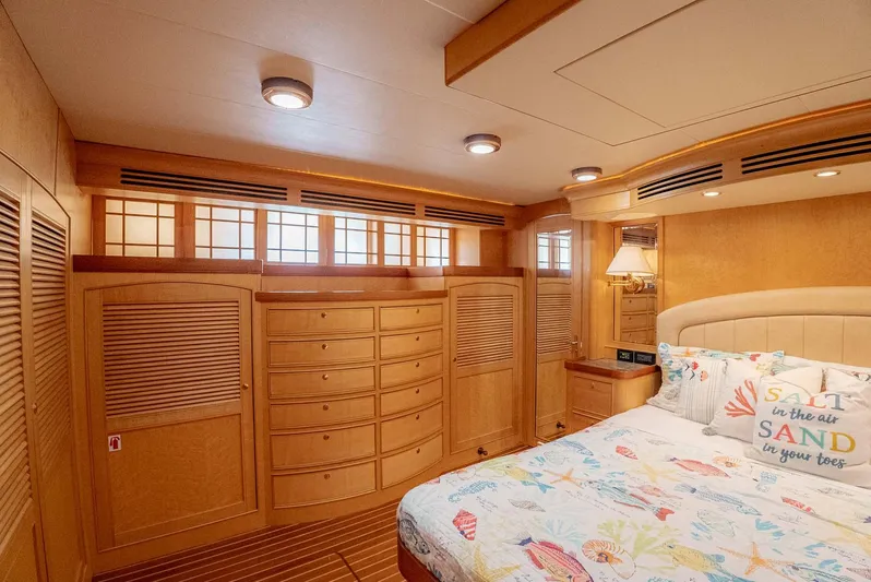 Someday Came Yacht Photos Pics Luxurious bedroom interior of 2006 Marlow 72E LRC yacht with wooden cabinetry and cozy bedding.