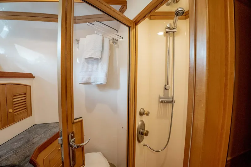 Someday Came Yacht Photos Pics Luxurious bathroom in 2006 Marlow 72E LRC yacht with wooden accents and modern shower.