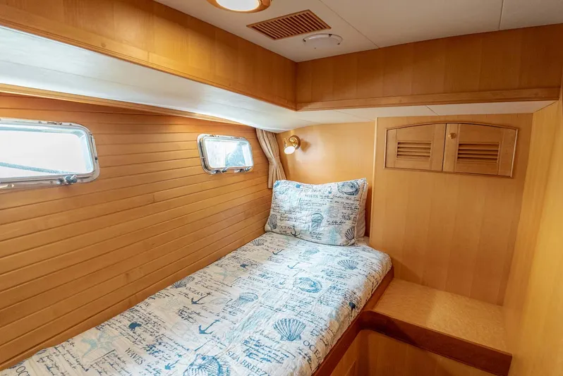 Someday Came Yacht Photos Pics Cozy cabin interior of 2006 Marlow 72E LRC yacht with nautical-themed bedding.
