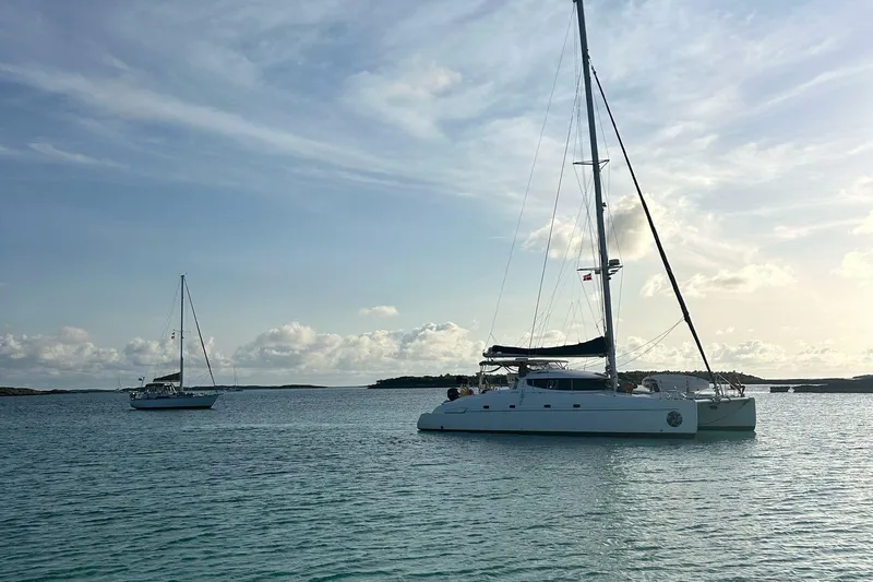 Thalassa Yacht Photos Pics 2005 Fountaine Pajot Bahia 46 catamaran sailing on calm waters under a cloudy sky.