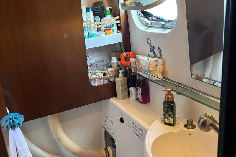 Thalassa Yacht Photos Pics Bathroom interior of 2005 Fountaine Pajot Bahia 46 catamaran, featuring toiletries and a porthole.