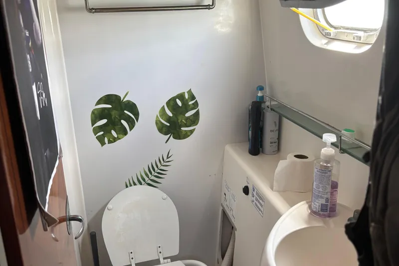 Thalassa Yacht Photos Pics Bathroom interior of 2005 Fountaine Pajot Bahia 46 catamaran with tropical leaf decor.