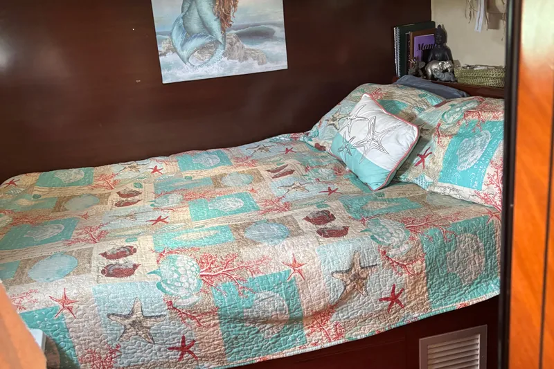 Thalassa Yacht Photos Pics Cozy cabin bed with nautical-themed quilt on 2005 Fountaine Pajot Bahia 46 yacht.