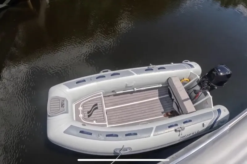 Thalassa Yacht Photos Pics Inflatable boat on water, featuring a motor and seating, near a Fountaine Pajot Bahia 46.