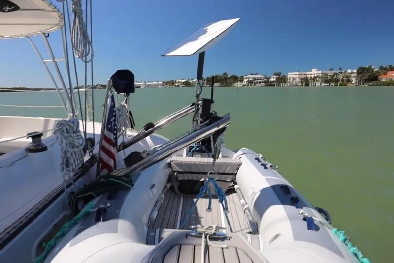 Thalassa Yacht Photos Pics 2005 Fountaine Pajot Bahia 46 catamaran with dinghy on calm waters.