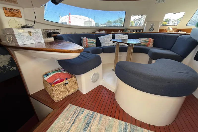 Thalassa Yacht Photos Pics Cozy interior of 2005 Fountaine Pajot Bahia 46 catamaran with blue seating and wooden accents.