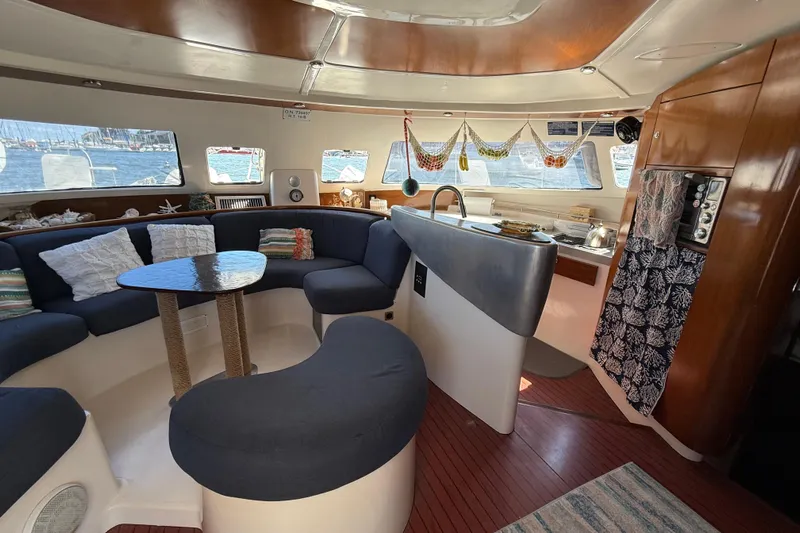 Thalassa Yacht Photos Pics Interior of 2005 Fountaine Pajot Bahia 46 catamaran with cozy seating and kitchen area.