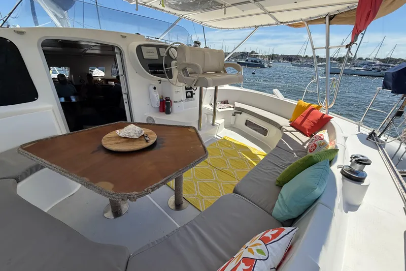 Thalassa Yacht Photos Pics Spacious deck of 2005 Fountaine Pajot Bahia 46 catamaran with colorful cushions and table.