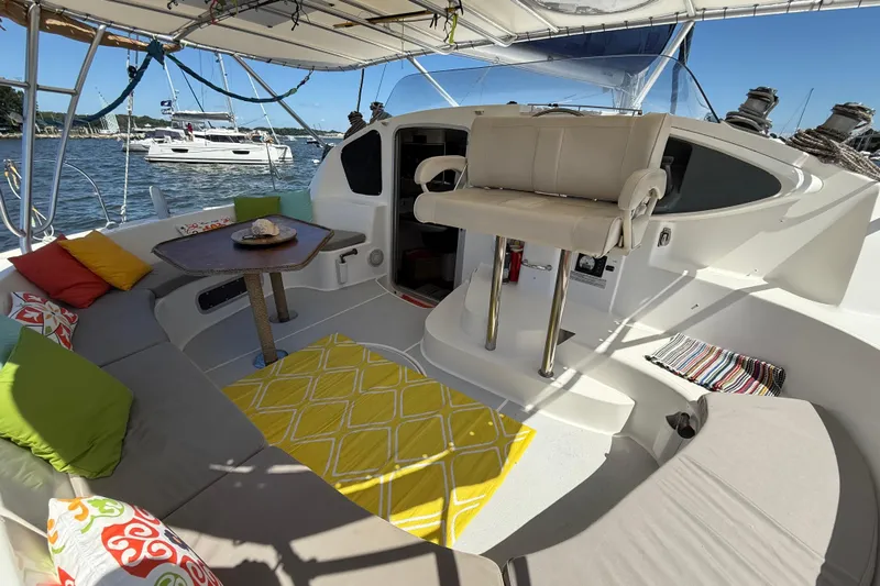 Thalassa Yacht Photos Pics Spacious 2005 Fountaine Pajot Bahia 46 catamaran cockpit with colorful cushions and seating.