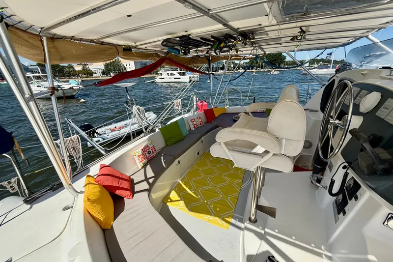 Thalassa Yacht Photos Pics 2005 Fountaine Pajot Bahia 46 catamaran cockpit with colorful cushions and steering wheel.