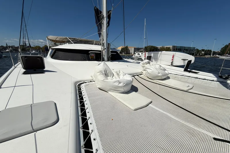 Thalassa Yacht Photos Pics 2005 Fountaine Pajot Bahia 46 catamaran deck with netting and cushions in marina.