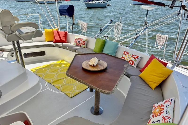 Thalassa Yacht Photos Pics Luxurious 2005 Fountaine Pajot Bahia 46 yacht deck with colorful cushions and table.