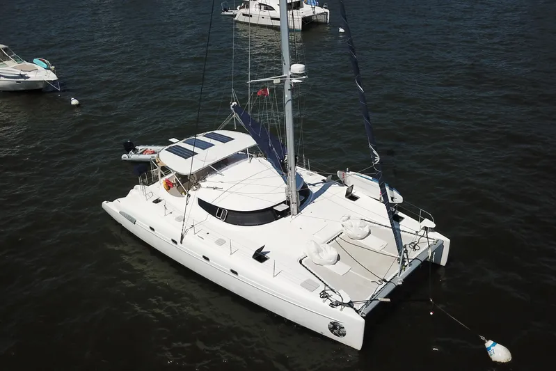 Thalassa Yacht Photos Pics 2005 Fountaine Pajot Bahia 46 catamaran anchored on calm water.