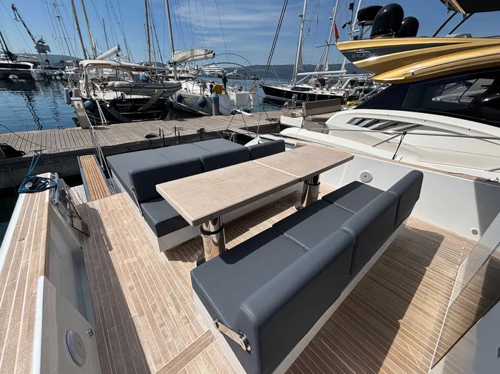 Barbarossa Yacht Photos Pics 2024 Fiart 43 Seawalker yacht with elegant seating and table, docked at a marina.