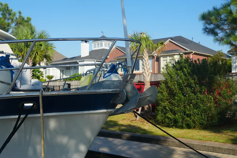 God's Favor Yacht Photos Pics 1986 DeFever 53 POC yacht docked near residential homes, surrounded by lush greenery.