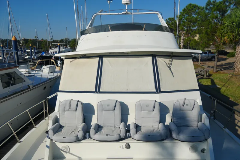 God's Favor Yacht Photos Pics 1986 DeFever 53 POC yacht with four cushioned seats on deck, docked at marina.